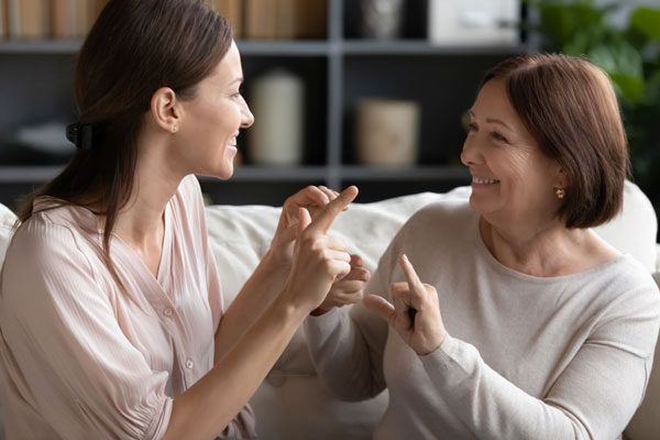 two adults doing asl